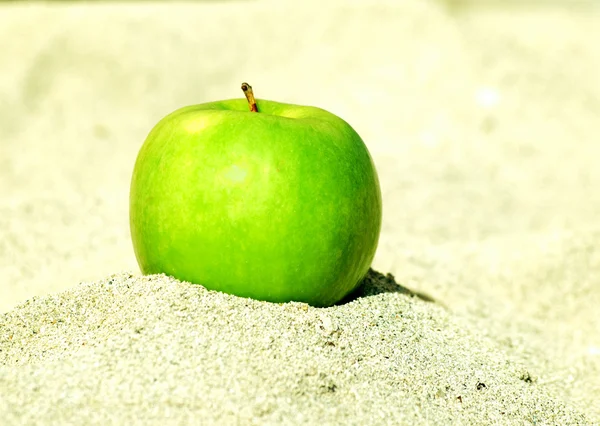 Το πράσινο μήλο σχετικά με λευκή άμμο — Φωτογραφία Αρχείου