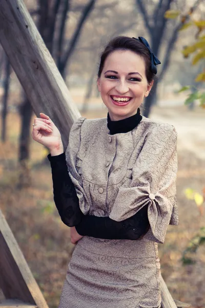 stock image A woman in an old dress on a walk near the wooden railing