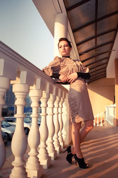 sütunları olan bir teras üzerinde eski bir elbise içinde bir kadın