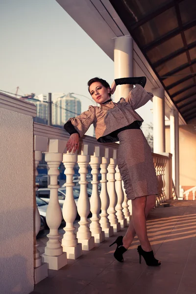 eski bir elbise poz sütunları olan bir teras üzerinde bir kadın