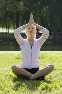 genç kadın meditasyon poz arka ışık bir parkta çim
