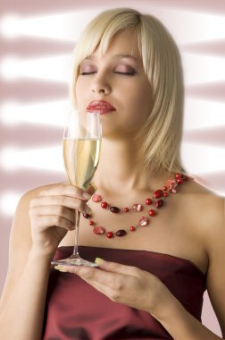 cute blond with cup of champagne in act to smell it clipart