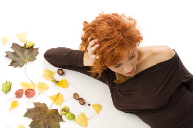 amazing shot of red haired woman laying down on white floor with autumn leaves all around clipart