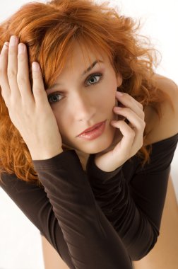 Kızıl saçlı güzel kadın kamera anlamlı gözleri ile bakarak üstünden nive kapat