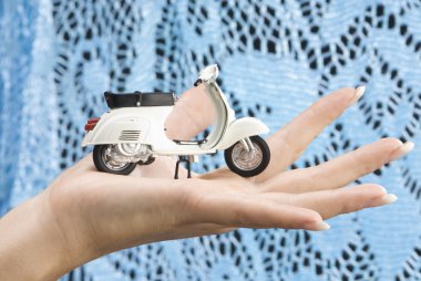 nice close up of a hand with an italian style motor cycle,the famous vespa clipart