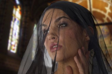 cute woman like widow with a black transparent veil on her face in church clipart