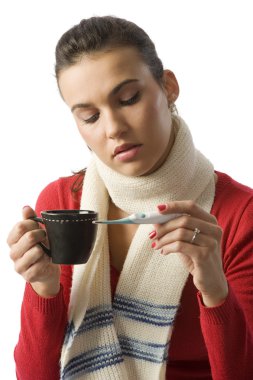 woman with a cup of hot drink looking sick checking her body temperature clipart