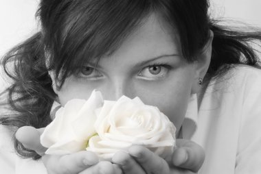 nice black and white portrait of a young woman with roses in her hands smelling and smiling with her fair eyes clipart