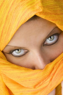 attactive and strong eyes behind an orange scarf used like a burka clipart