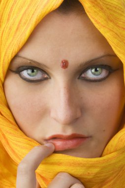 attactive and strong eyes behind an orange scarf used like a burka clipart