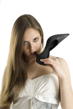 a fine dressed girl biting her shoes heel looking at the camera with sexy eyes