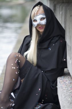 attractive girl in canival costume with mask and hood showing legs clipart