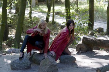 gece yaratığı gibi seksi ve güzel sarışın ve esmer birlikte deri elbise ve poz park