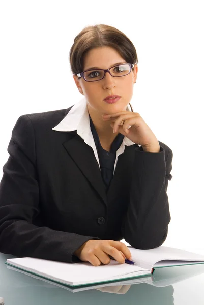 一个年轻女子在黑色外套和白色衬衫和一条领带 坐在一个办事处表后面和玩眼镜 — 图库照片