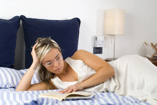 寝る前にベッドに夜の本 読むブロンドの髪と美しい若い女性 — ストック写真