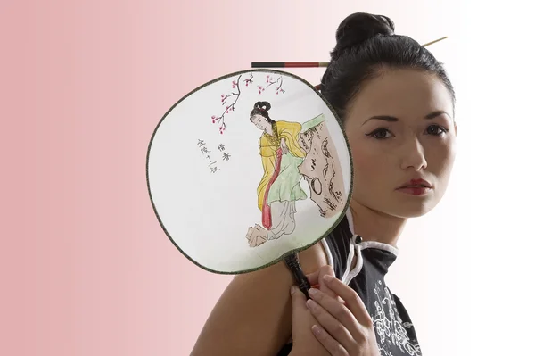 东方的年轻女子 在她的头发穿黑色东方衬衫与日本风扇和筷子 — 图库照片