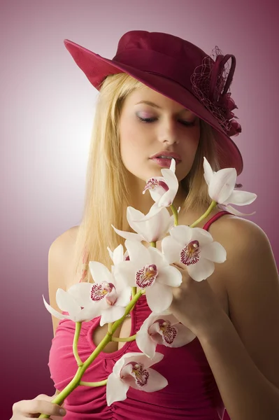 Piękna Młoda Kobieta Red Hat Czerwony Top Zachowując Niektóre Kwiaty — Zdjęcie stockowe