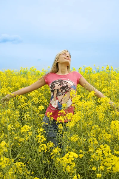 Šťastná dívka ve žlutém poli — Stock fotografie