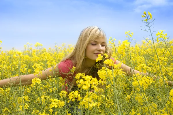 Ευτυχής Ξανθιά Κοπέλα Ανοιχτές Αγκάλες Μυρίζοντας Μερικά Λουλούδια Κίτρινο Πεδίο — Φωτογραφία Αρχείου