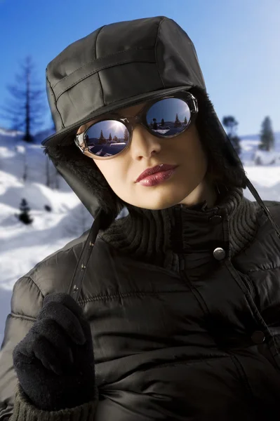 有魅力的年轻女人用黑色风衣外套和黑色冬季帽子和太阳镜 — 图库照片