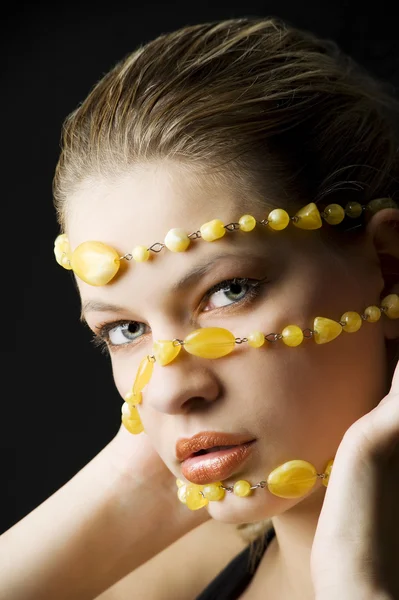一个年轻漂亮的金发女郎黄色宝石项链在她的脸近距离美女射击 — 图库照片