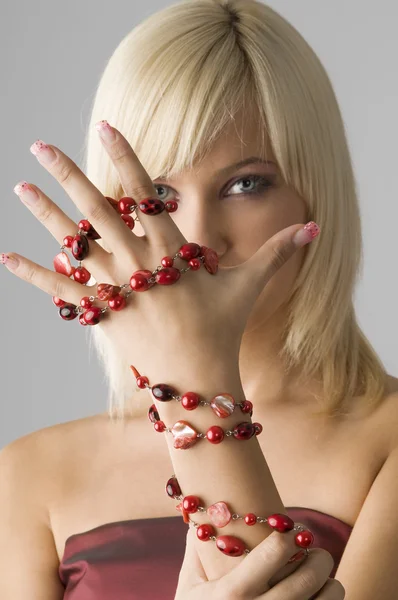 赤のネックレス ネックレスの焦点とのブロンドの女の子の手上のクローズ アップ — ストック写真