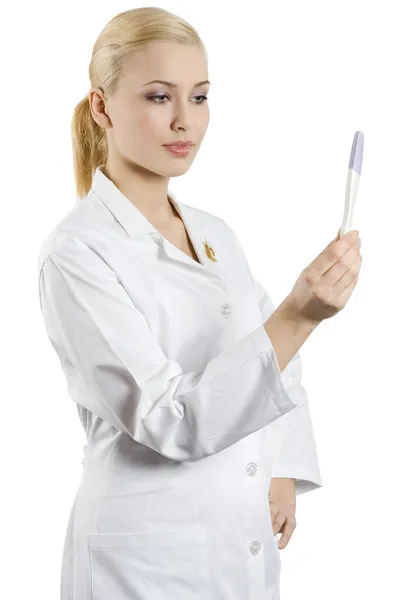 年轻的金发女郎 作为一名护士查找和显示怀孕测试 — 图库照片