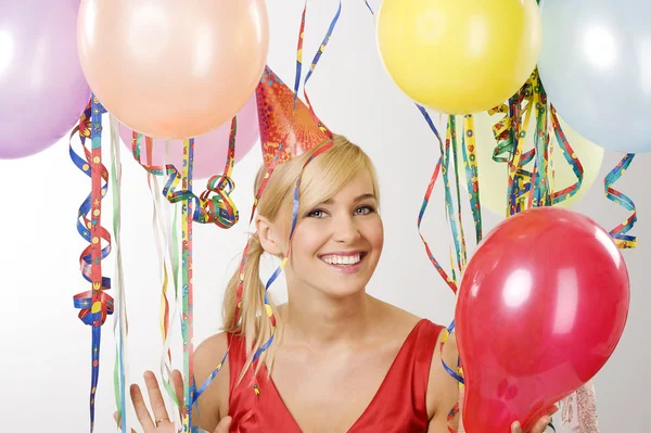 Red dressed girl in party with balloons — Stock Photo, Image