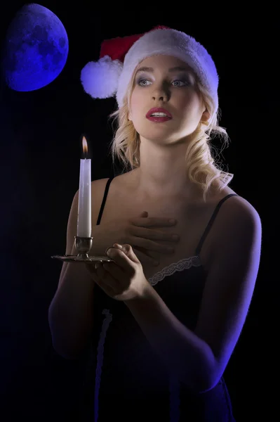 かわいい 魅力的な若い女性のナイトガウン Ant のキャンドルと暗闇の中で探しているクリスマス帽子 — ストック写真