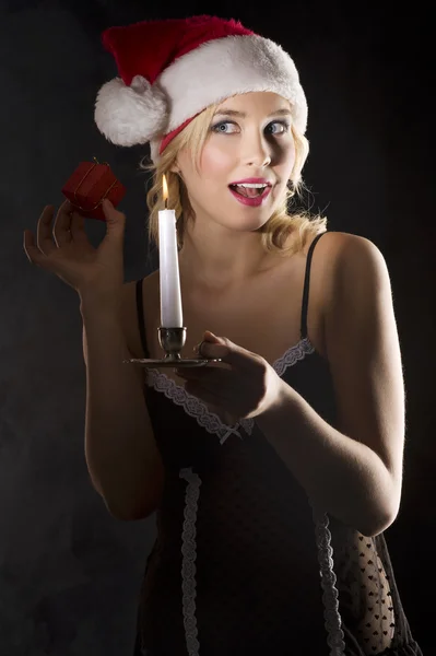 Santa claus v temnotě s svíčku a dárek — Stock fotografie