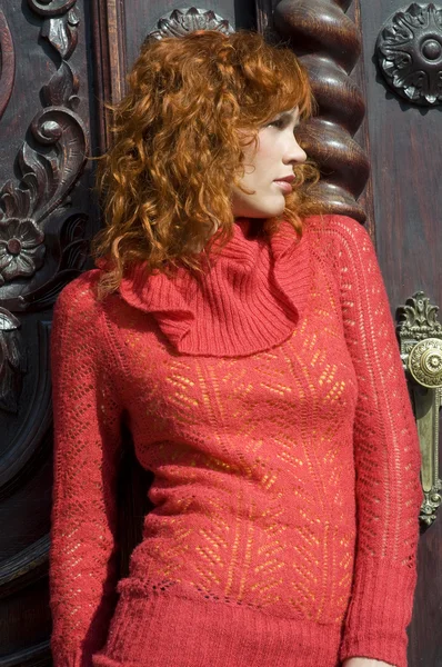 Zamknij Młodą Piękną Kobietą Czerwony Sweter Pobliżu Starych Drzwi — Zdjęcie stockowe