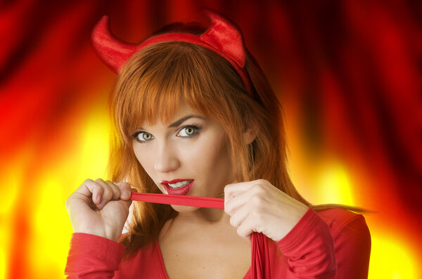 close up poertrait of a red haired girl with horns like a devil looking in camera