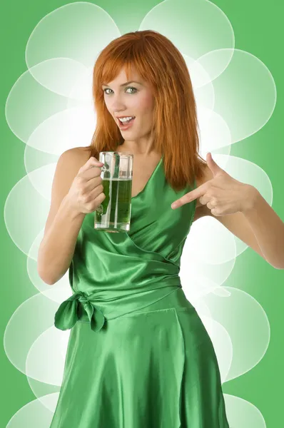 幸せな緑色のビールのガラスを示す緑のドレスでかわいいのアイルランドの少女 — ストック写真