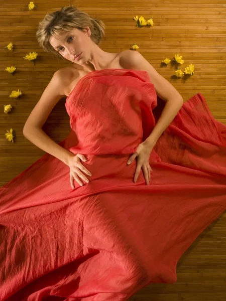 Roztomilý Atraktivní Blondýnka Pod Červenou Měkké Tkaniny Květinami Okolí — Stock fotografie