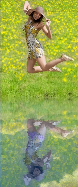 色のドレスと帽子フィールドにジャンプの運動若い女性 — ストック写真