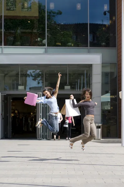 Dos Jóvenes Saltando Frente Centro Comercial Con Bolsas Compras — Foto de Stock