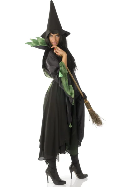 美丽的巫婆用笤帚在黑色和绿色的衣服和帽子 — 图库照片