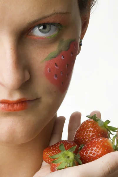 她脸上和有色的眼睛上绘了年轻和可爱的黑发女人大草莓的肖像 — 图库照片