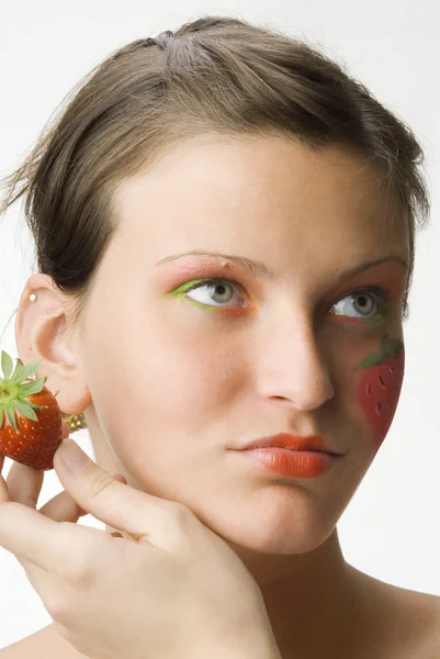 彼女の顔と色の目に描かれた大きなイチゴと若い かわいいブルネットの肖像画 — ストック写真