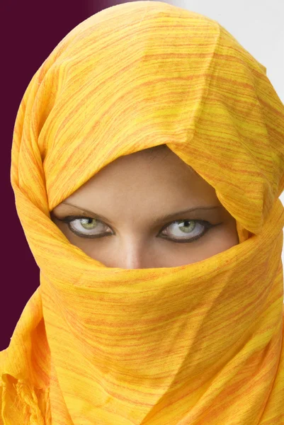 stock image Attactive and strong eyes behind an orange scarf used like a burka