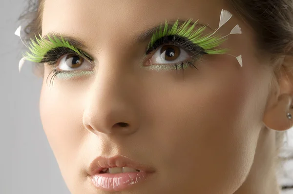 年轻漂亮的女人和人工绿色睫毛的可爱肖像 — 图库照片