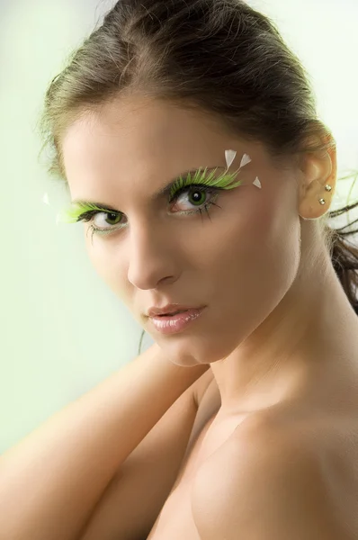 与人工绿色睫毛和绿色的眼睛的年轻和可爱的女人肖像 — 图库照片