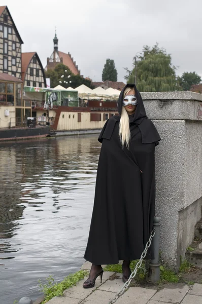 Sarışın Maskesi Siyah Pelerin Bulutlu Karnaval Gün Mahallede Nehri Yakınında — Stok fotoğraf
