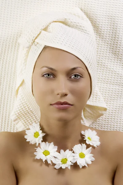 Pretty Young Woman Bath Towel Flowers Necklace Laying — Zdjęcie stockowe