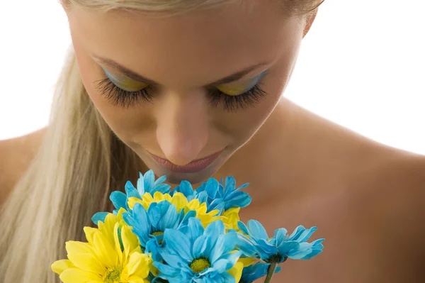 有彩色化妆法 中的可爱金发女郎闻到一些雏菊 — 图库照片