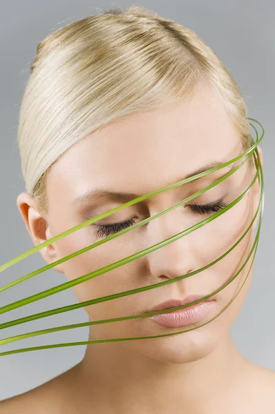 Flicka med gräs över ansiktet — Stockfoto