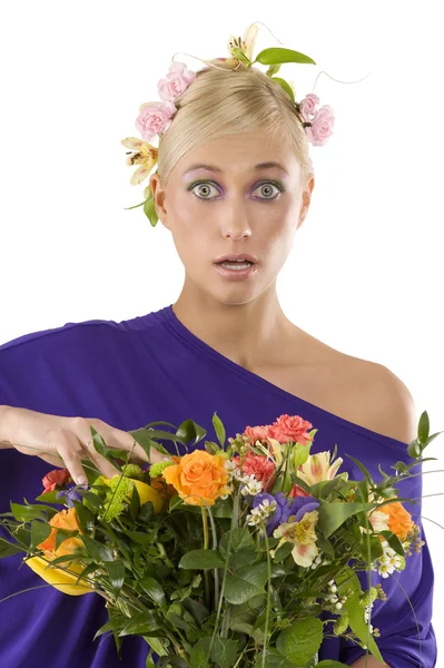 年轻漂亮的金发女孩在紫罗兰色礼服与花和花束闭门带着惊讶的表情看关闭 — 图库照片