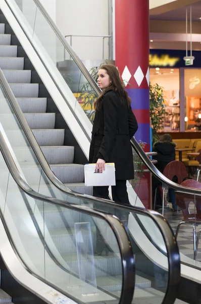 美女在黑色大衣走楼梯在商务中心 — 图库照片