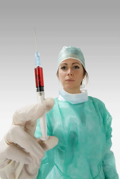 一个年轻的护士用注射器的血完全操作穿裙子 — 图库照片