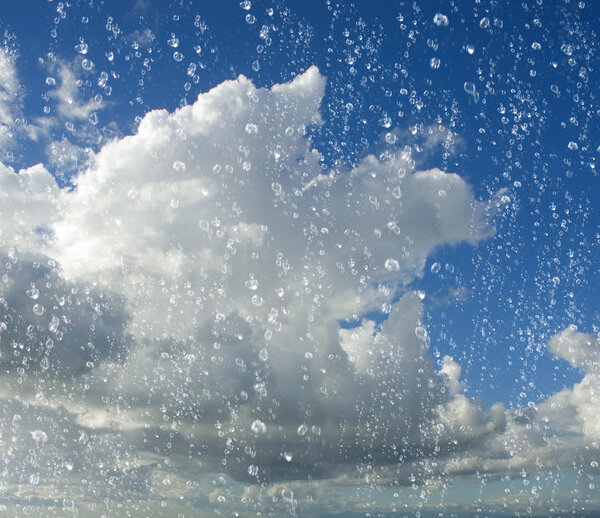 drops of rain with a cloudy blue sky in background